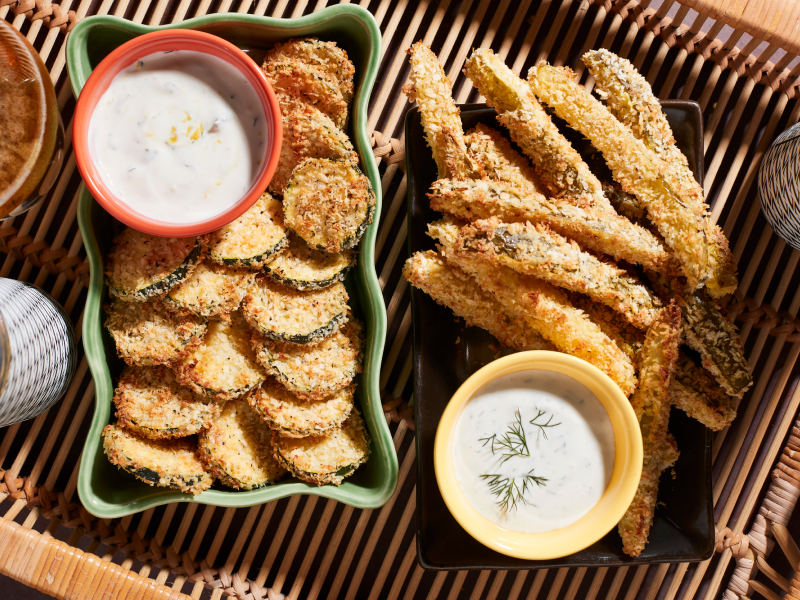 Plates of fried vegetables and dishes of vegan queso. Plates of fried vegetables and dishes of vegan queso.