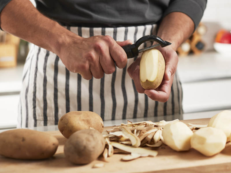 A person peeling potatoes.
