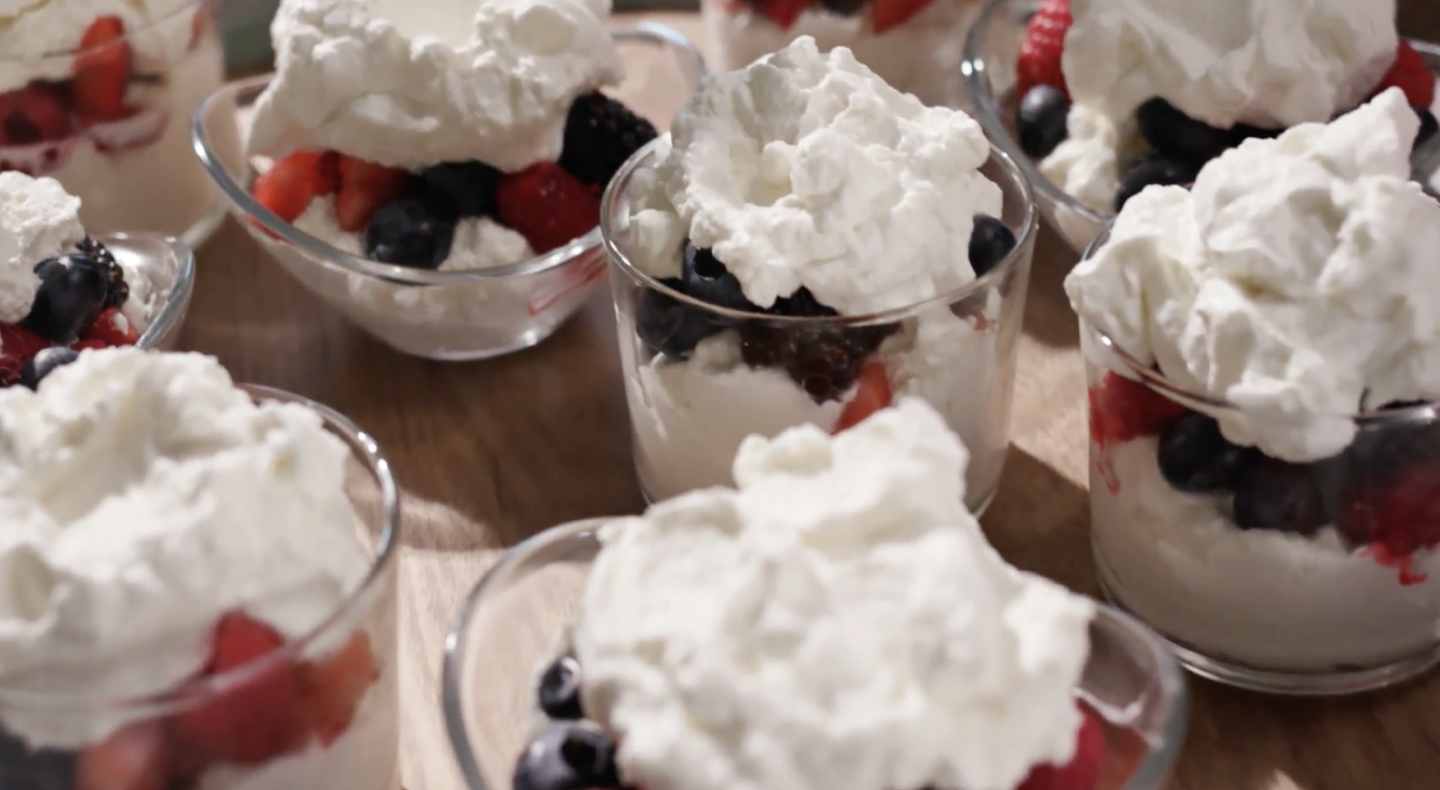 Berry and yogurt parfait desserts with whipped cream topping Berry and yogurt parfait desserts with whipped cream topping