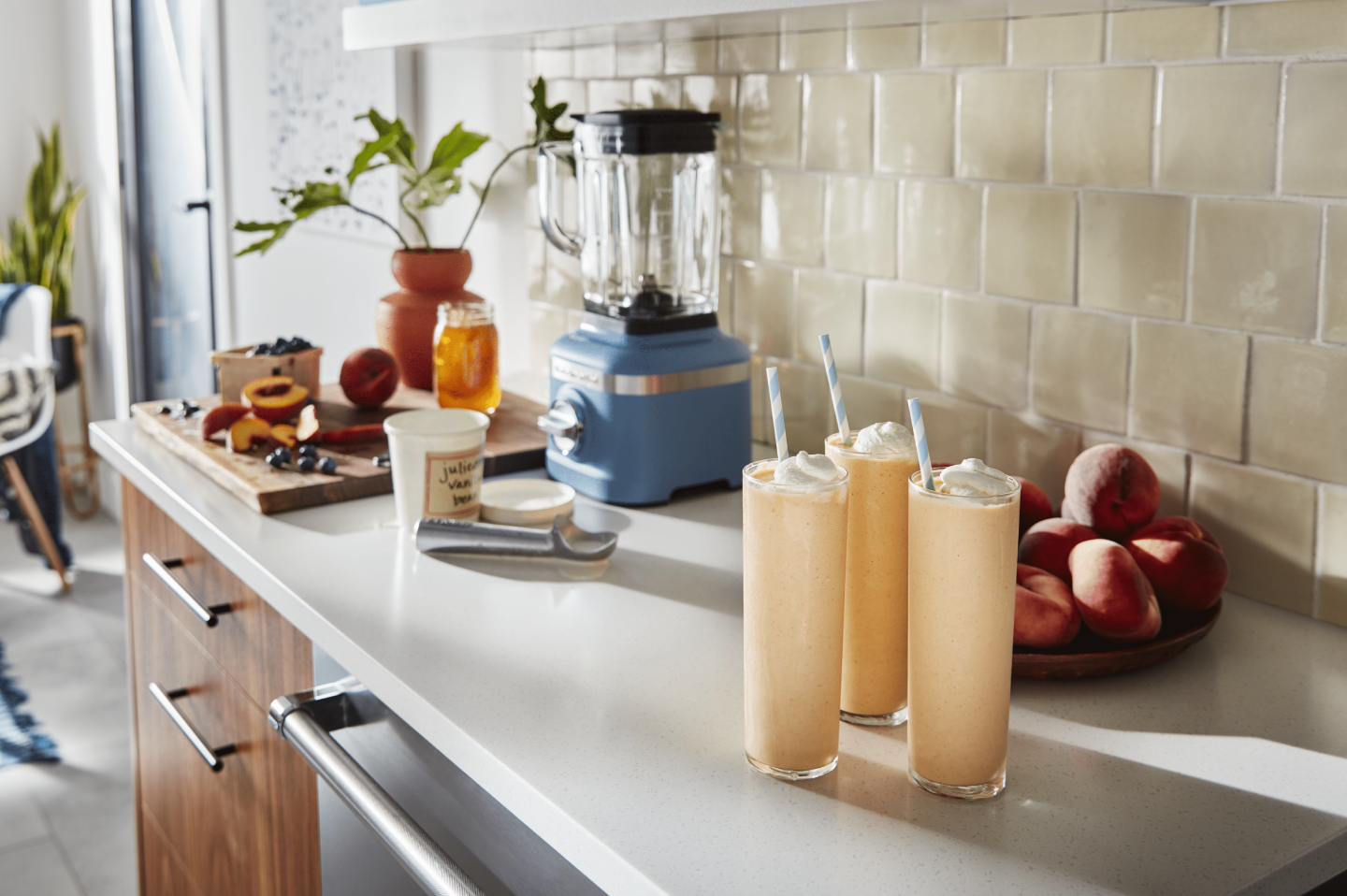 Three glasses of milkshakes topped with whipped cream on a countertop Three glasses of milkshakes topped with whipped cream on a countertop