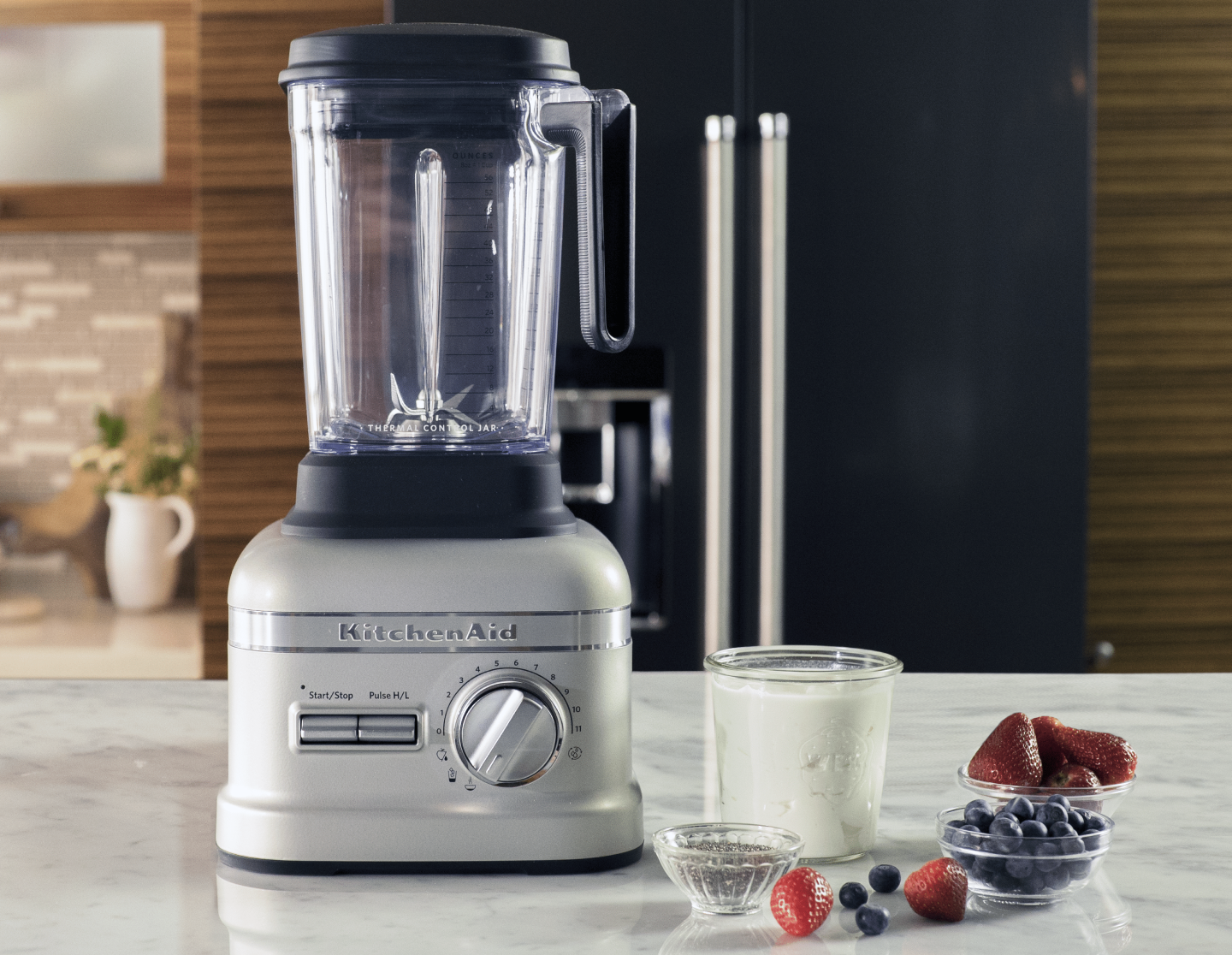 Fruits and berries next to a white KitchenAid® blender on a countertop Fruits and berries next to a white KitchenAid® blender on a countertop