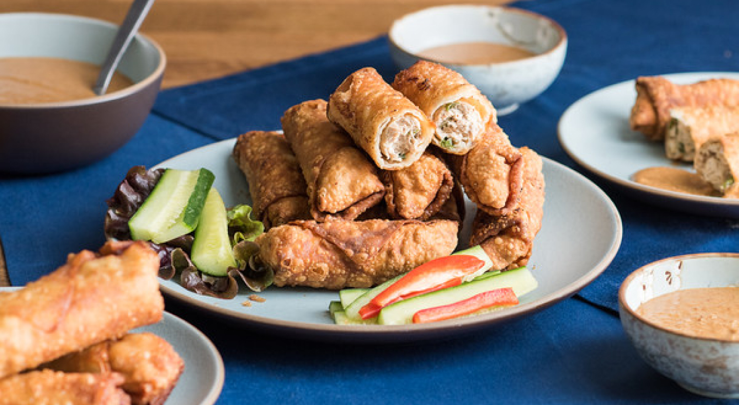 A plate of eggrolls containing minced chicken A plate of eggrolls containing minced chicken