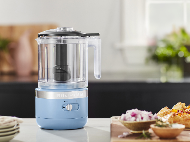 A KitchenAid® food processor with ingredients sitting next to it A KitchenAid® food processor with ingredients sitting next to it