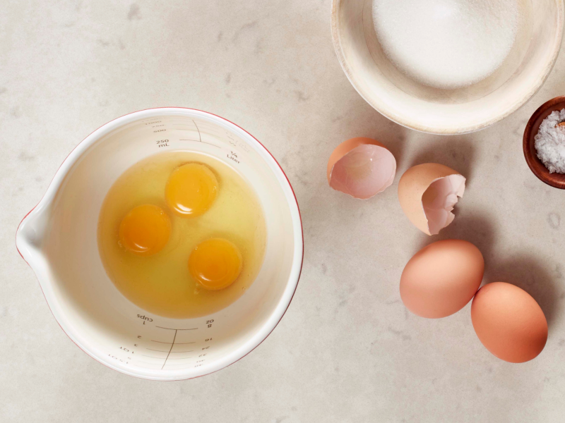 Three eggs in a bowl next to cracked egg shells Three eggs in a bowl next to cracked egg shells