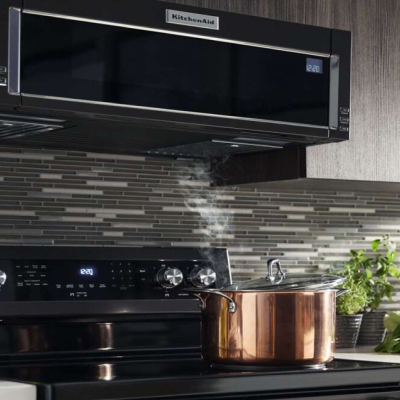 Pot of water with lid half-on boiling water on electric cooktop Pot of water with lid half-on boiling water on electric cooktop