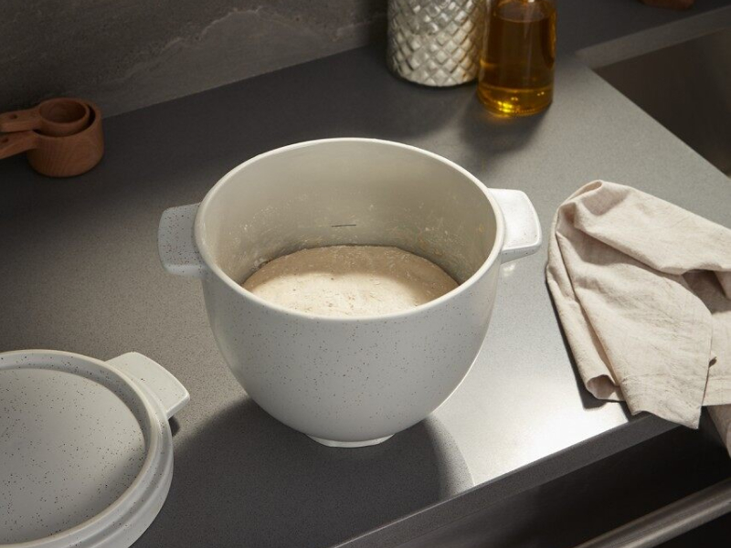 Bread dough proofing in a bread bowl on a countertop