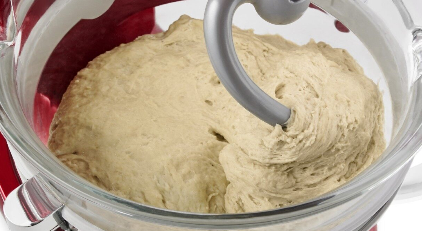 Close-up of a dough hook inside of bread dough in a stand mixer bowl Close-up of a dough hook inside of bread dough in a stand mixer bowl