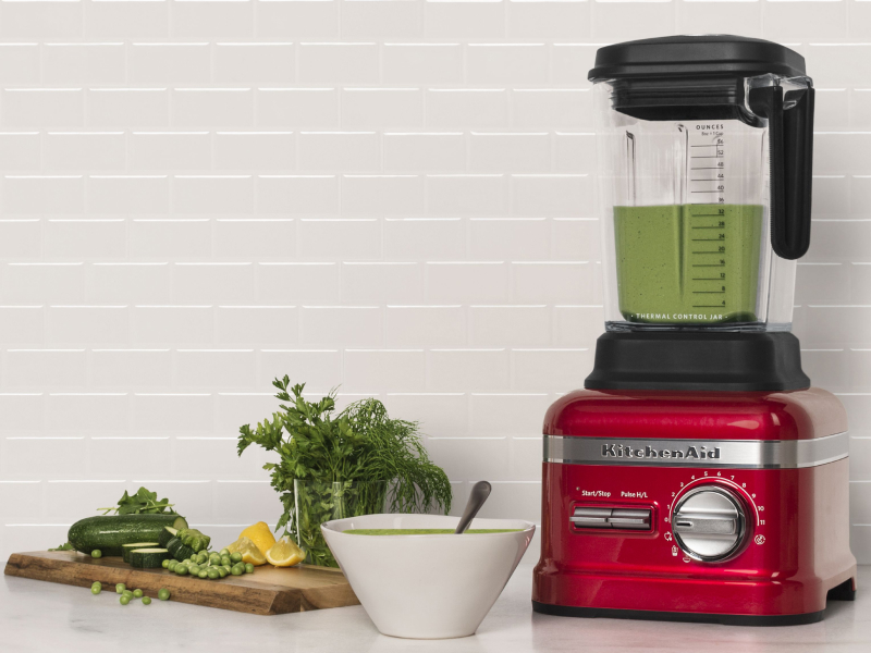 Red KitchenAid® blender next to various vegetables Red KitchenAid® blender next to various vegetables