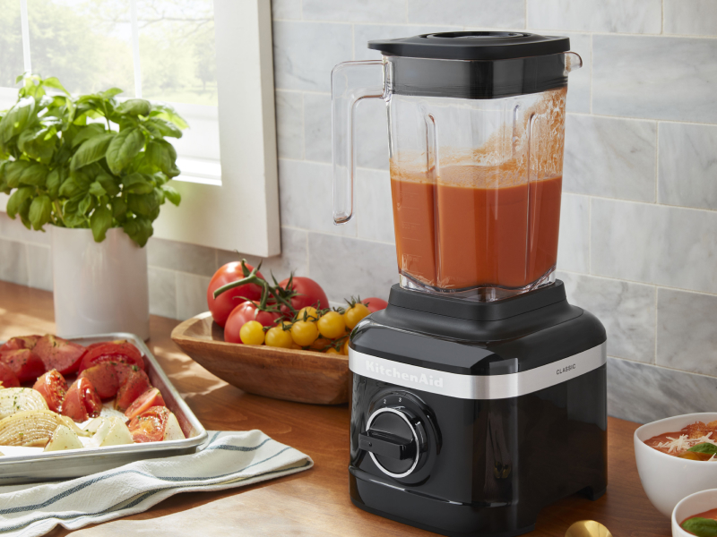 KitchenAid® blender filled with puree next to various ingredients KitchenAid® blender filled with puree next to various ingredients
