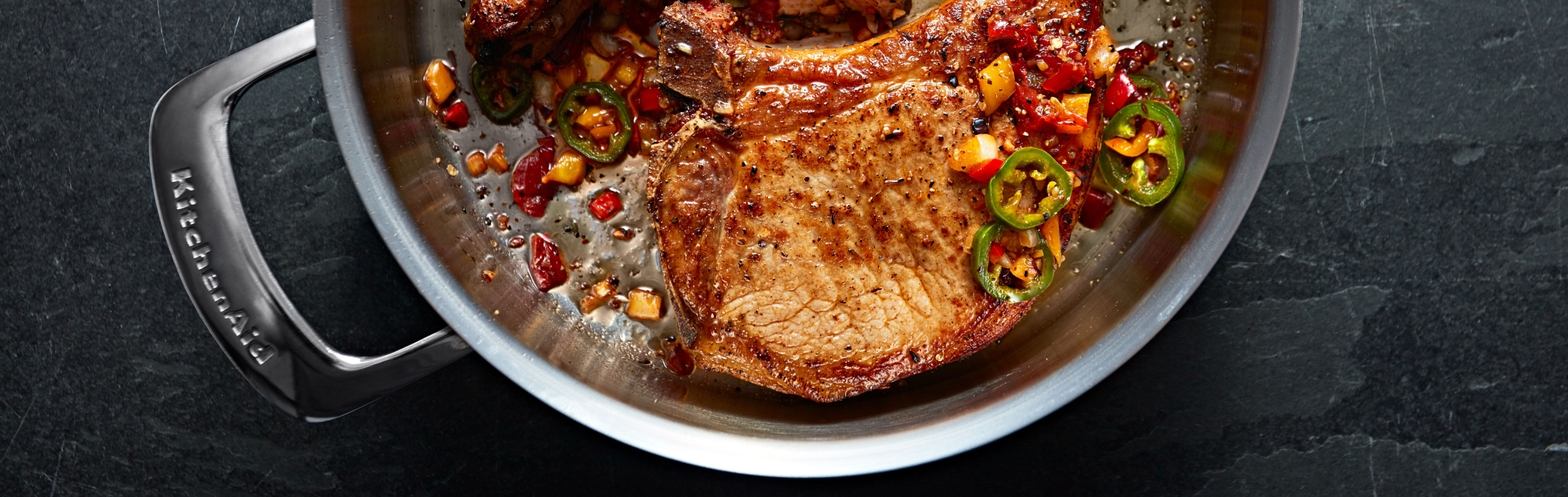 Steak in a KitchenAid® pan with various garnishes