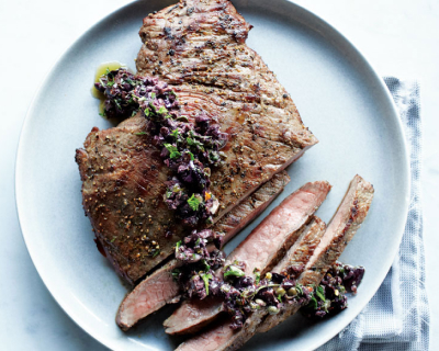 Seasoned steak half cut into slices garnished with vegetables