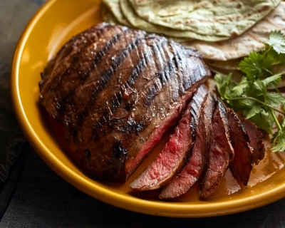 Sliced steak served on a plate with various sides