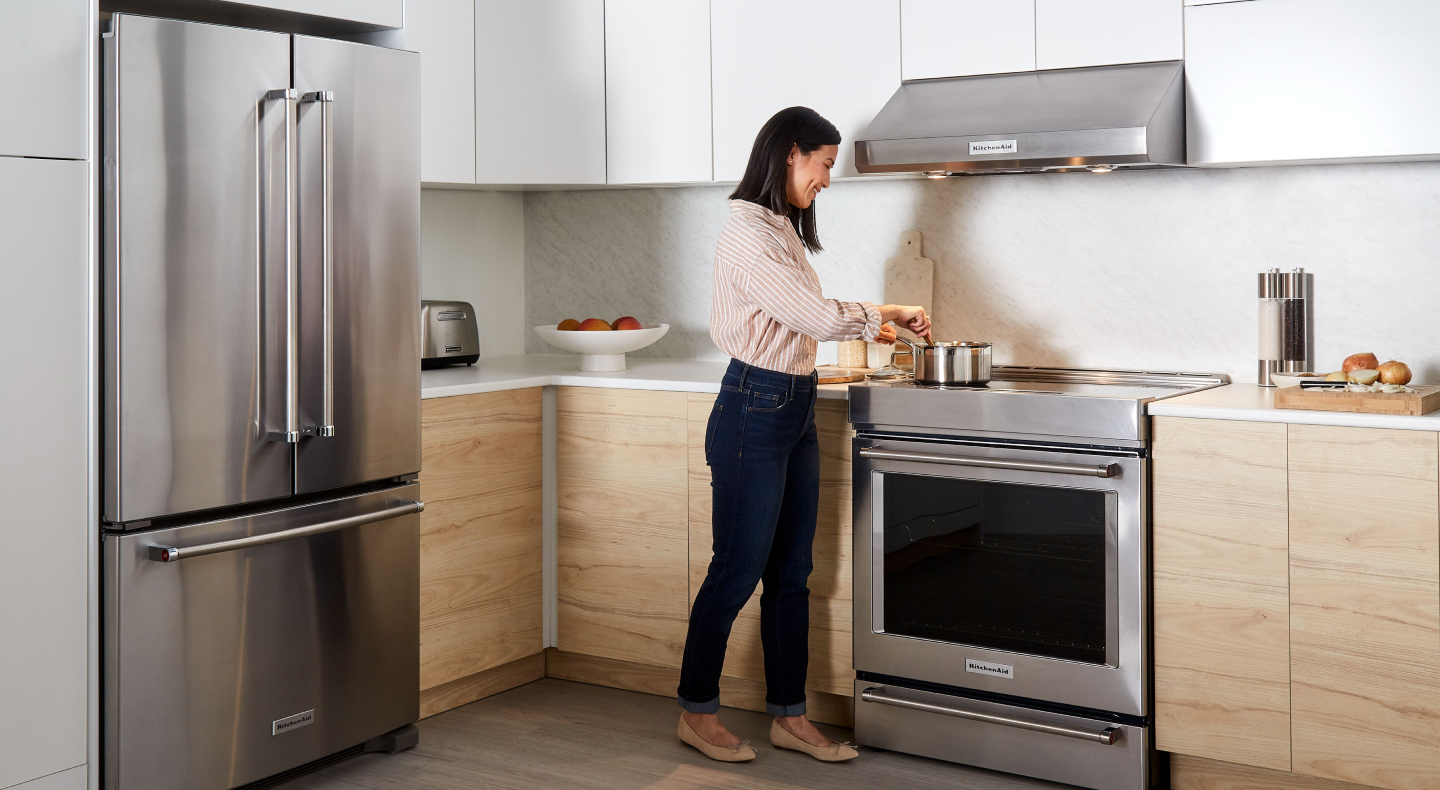 Person cooking at a KitchenAid® range Person cooking at a KitchenAid® range