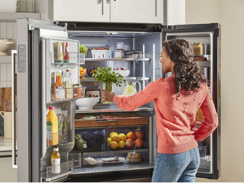 Person placing produce in a refrigerator Person placing produce in a refrigerator