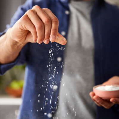 Person sprinkling seasoning