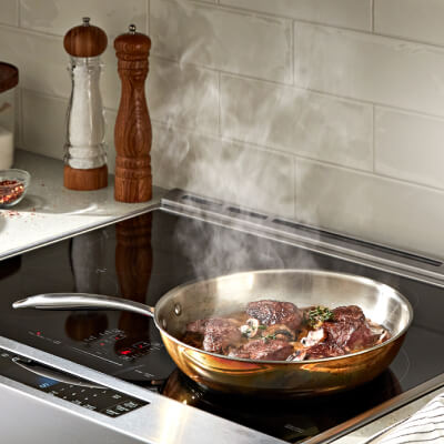 Steak cooking on a cooktop Steak cooking on a cooktop