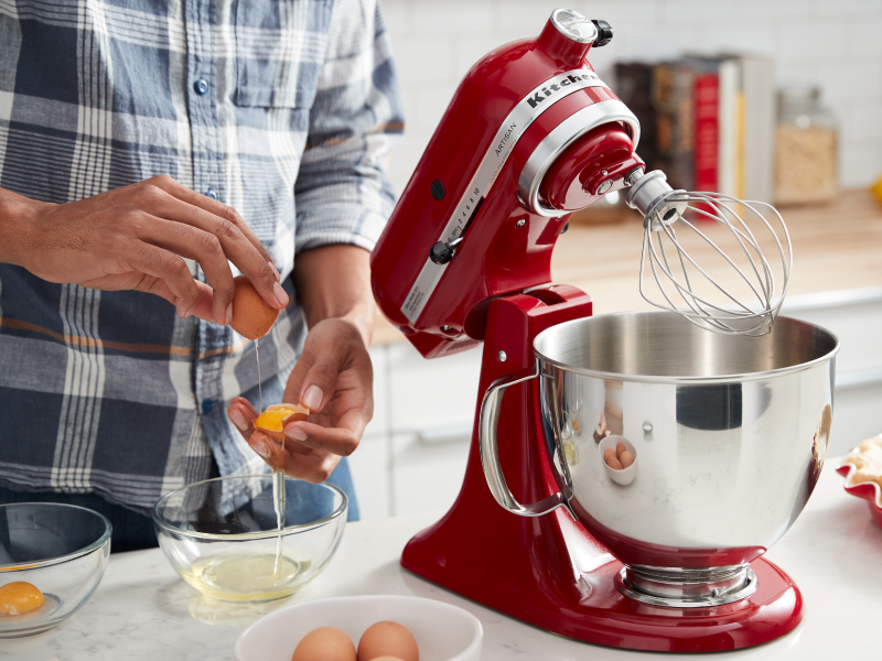 Hands slipping egg yolks between shells Hands slipping egg yolks between shells
