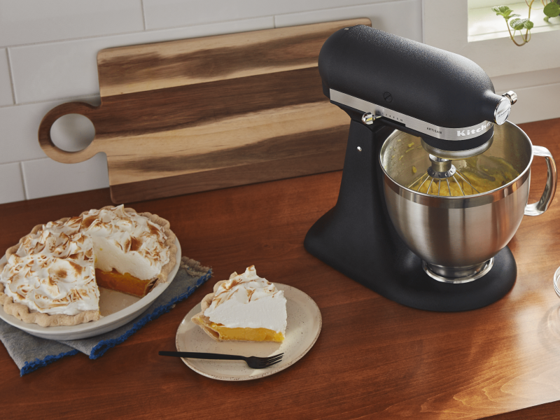 A pie plate of meringue pie with a slice cut out A pie plate of meringue pie with a slice cut out