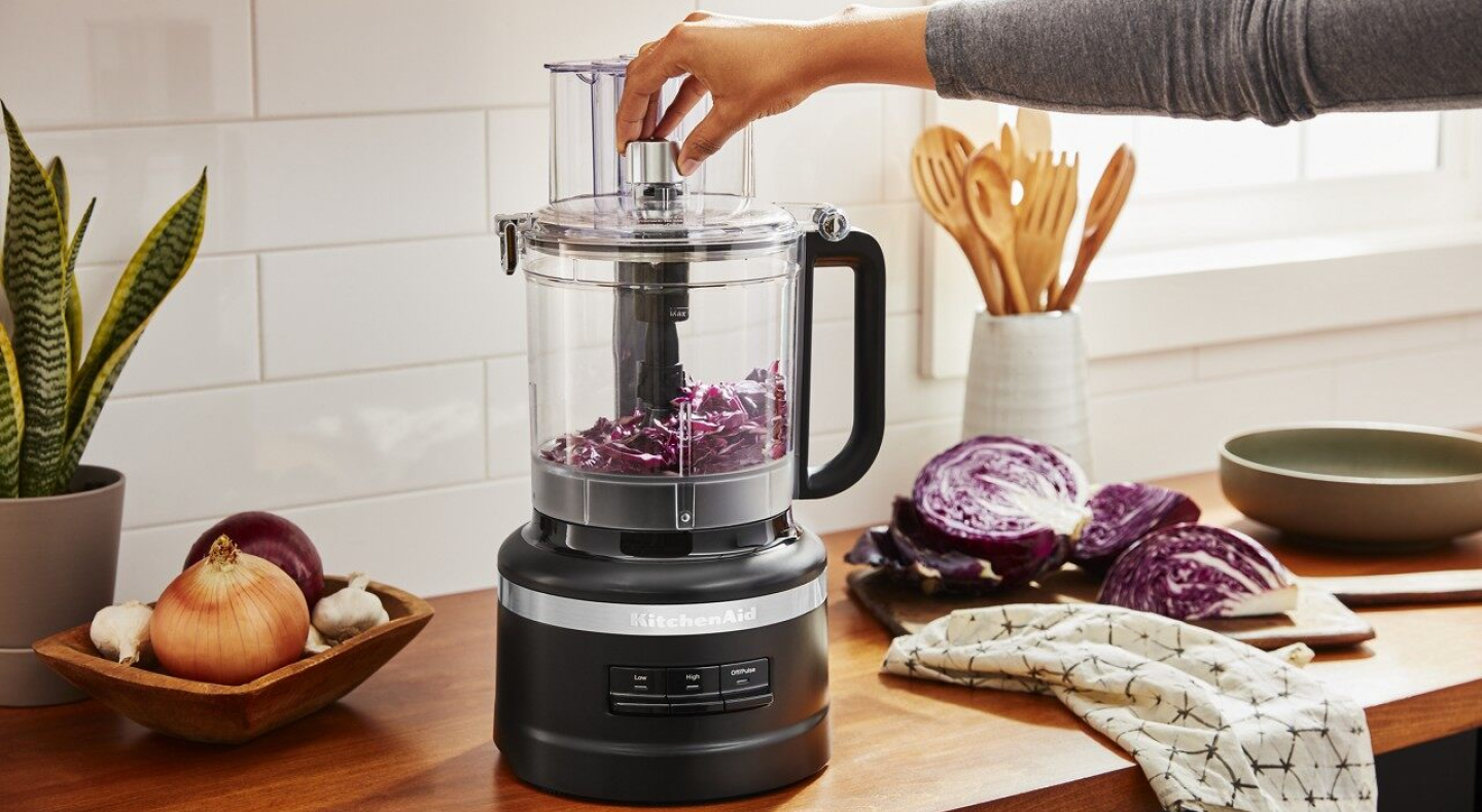 Woman dicing vegetables in a KitchenAid® food chopper Woman dicing vegetables in a KitchenAid® food chopper