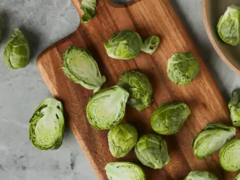 Bowl of brussel sprouts next to sliced brussel sprouts on a cutting board Bowl of brussel sprouts next to sliced brussel sprouts on a cutting board