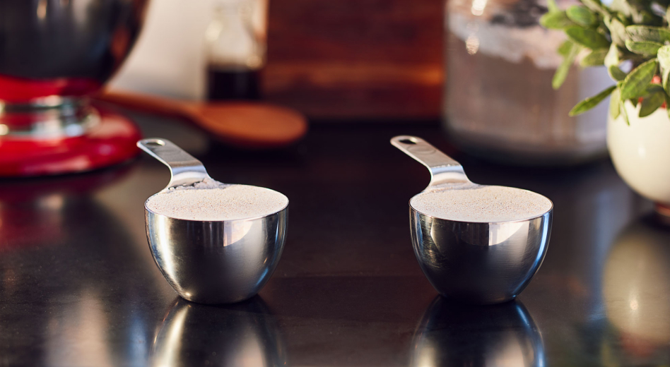 Two measuring cups filled with flour  Two measuring cups filled with flour