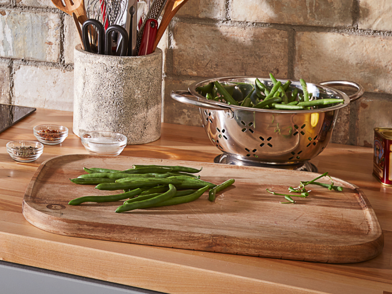 Fresh green beans on a wooden cutting board