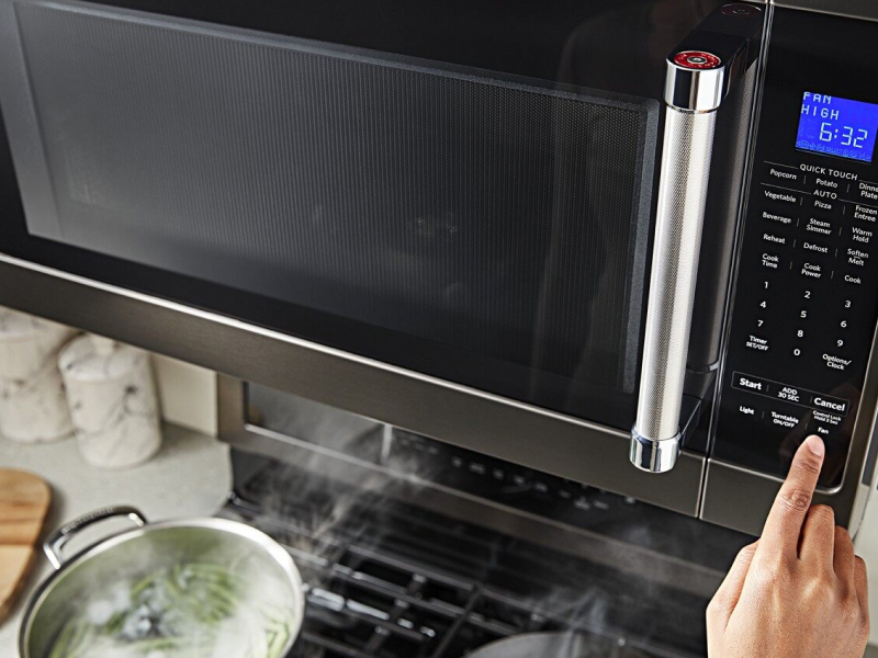 Person selecting a microwave preset button Person selecting a microwave preset button