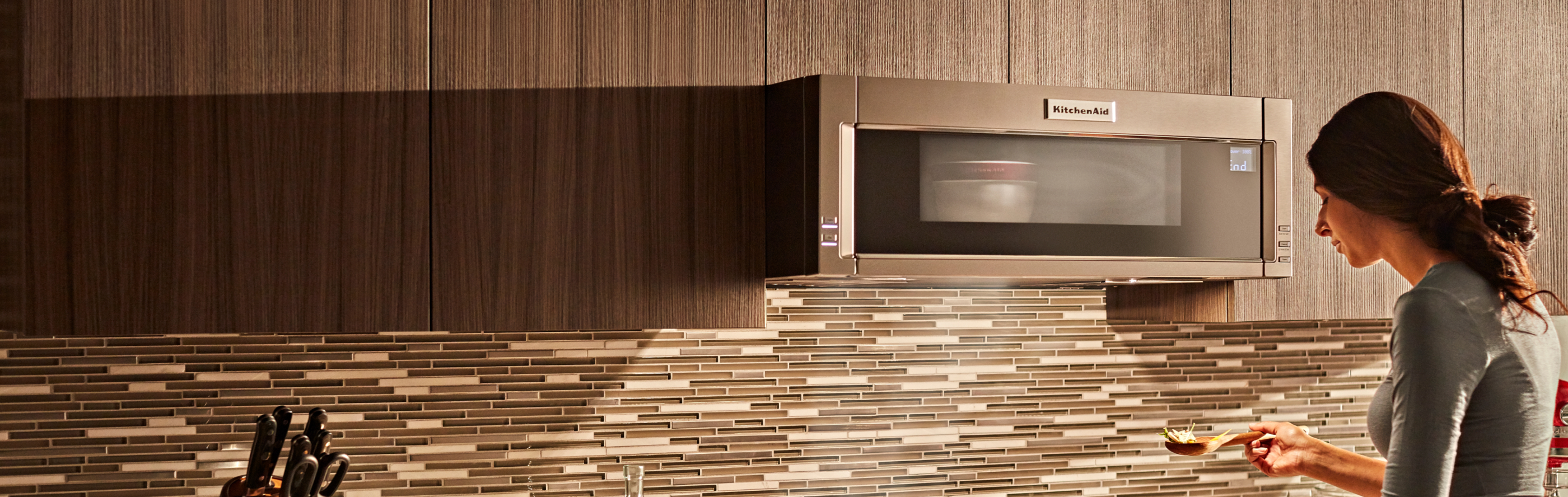 Person in front of a built-in KitchenAid® microwave