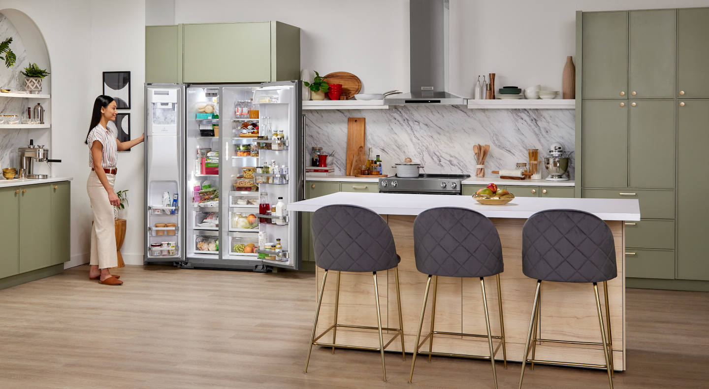 Person standing next to a refrigerator with the door open