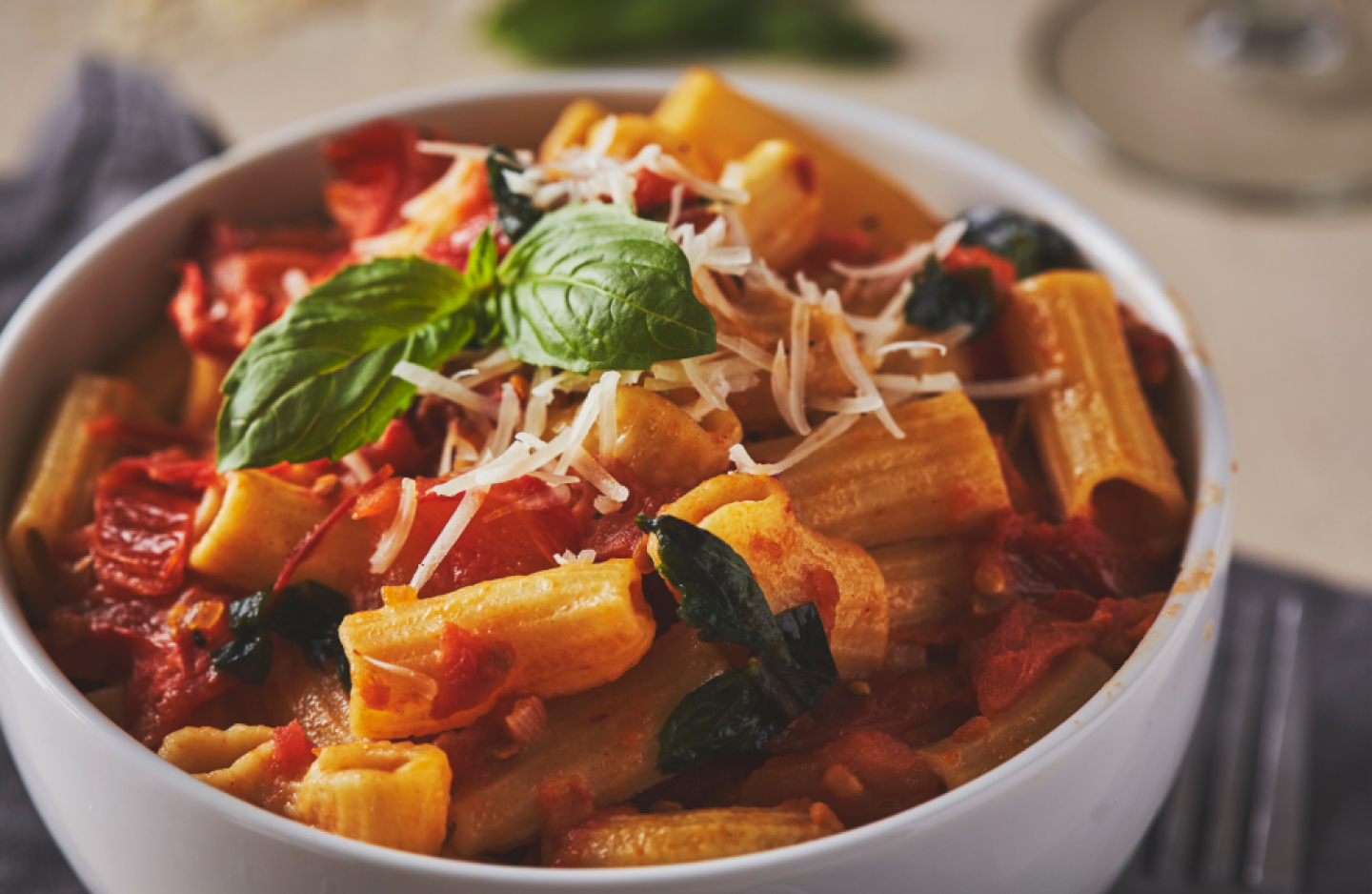 A bowl of rigatoni pasta with fresh tomato sauce, basil and cheese A bowl of rigatoni pasta with fresh tomato sauce, basil and cheese