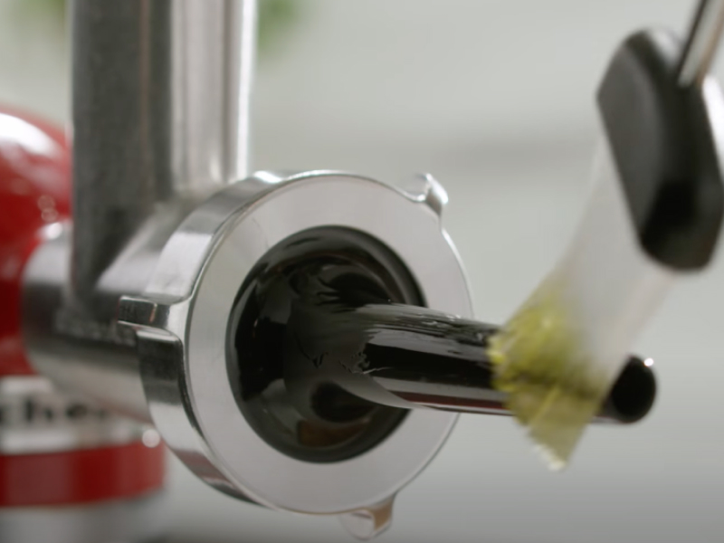 Person greasing the sausage stuffing tube