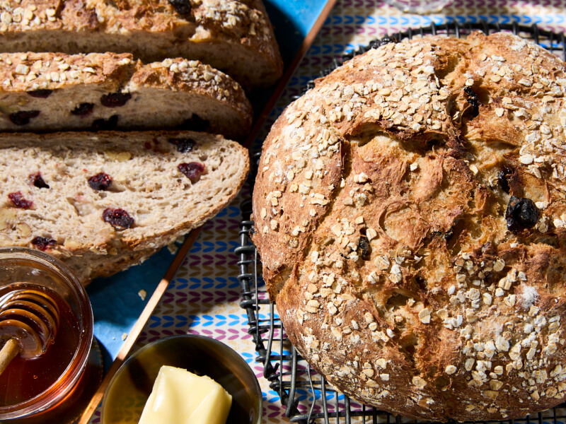 Loaf of bread with sliced bread and honey next to it