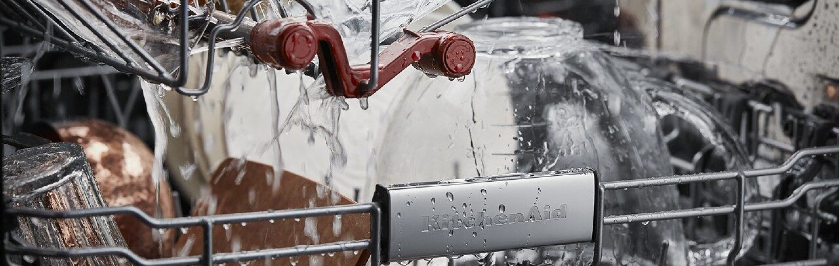 Closeup of the inside of KitchenAid® dishwasher with water spraying on the dishes