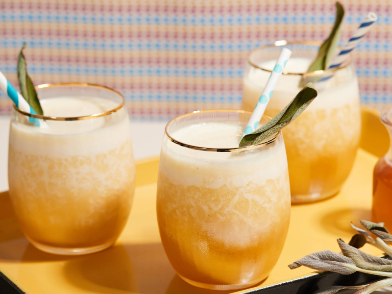 Fresh juice in serving cups with fruit pieces, straws and spoons Fresh juice in serving cups with fruit pieces, straws and spoons