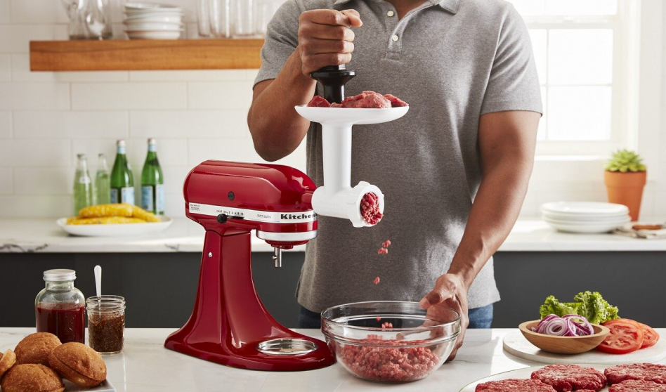 Man grinding meat for burgers using the KitchenAid® food grinder attachment Man grinding meat for burgers using the KitchenAid® food grinder attachment