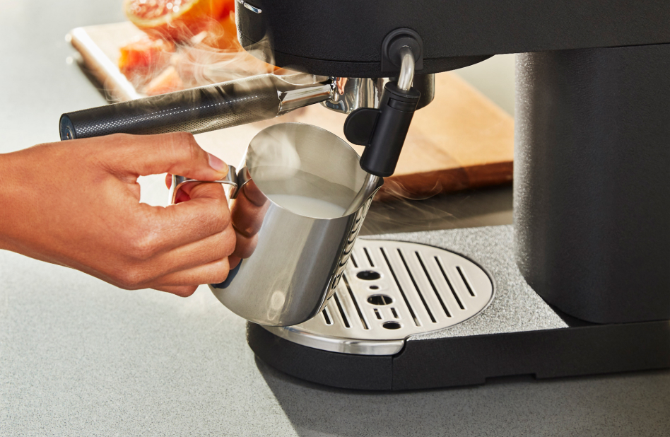 Close ups showing how to use a milk frother steam wand Close ups showing how to use a milk frother steam wand