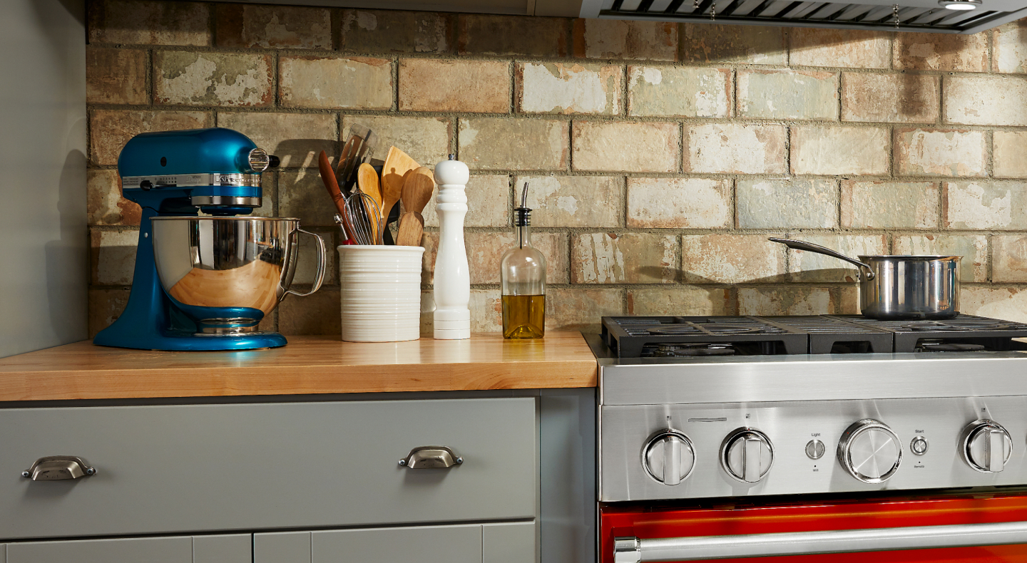 KitchenAid® stand mixer on kitchen counter above gray cabinetry KitchenAid® stand mixer on kitchen counter above gray cabinetry