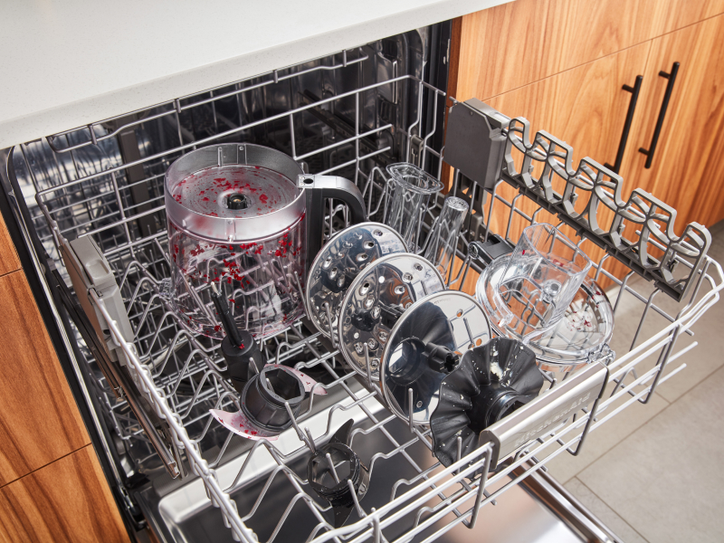 Stained food processor parts in open dishwasher rack