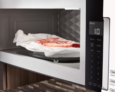 Meat on a plate inside microwave