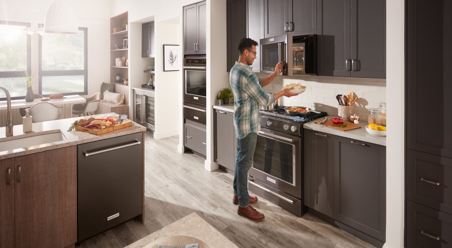 Person using microwave in modern kitchen