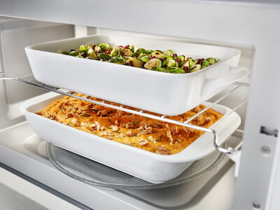 Two baking dishes inside a microwave