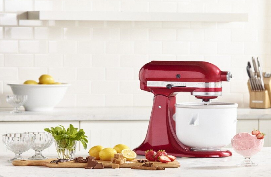 Red stand mixer with Ice Cream Maker attachment surrounded by ingredients and strawberry ice cream Red stand mixer with Ice Cream Maker attachment surrounded by ingredients and strawberry ice cream