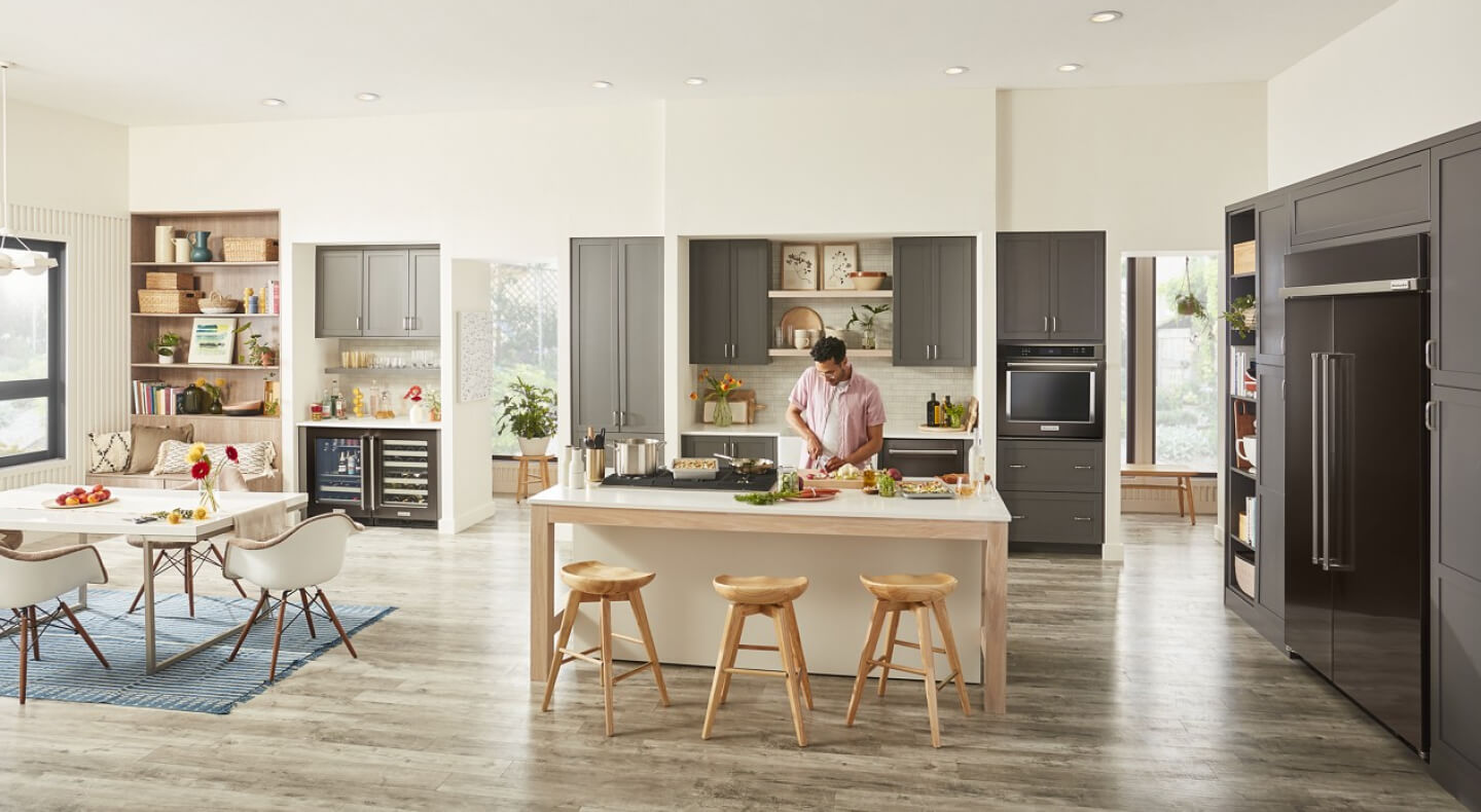 Person chopping produce on an island in modern kitchen Person chopping produce on an island in modern kitchen