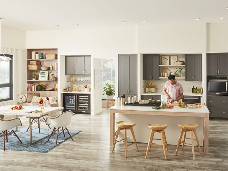Person chopping produce on an island in modern kitchen Person chopping produce on an island in modern kitchen