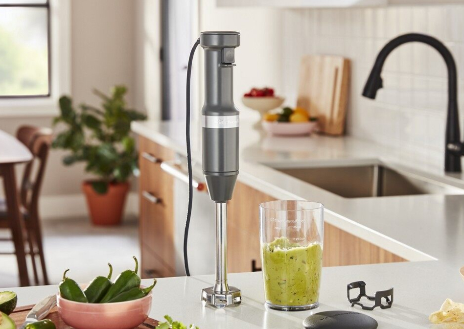 KitchenAid® hand blender next to blender jar with guacamole