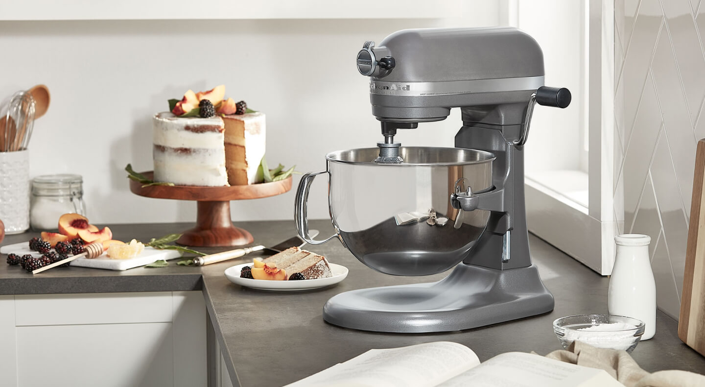 KitchenAid® bowl lift stand mixer next to layer cake on cake stand  KitchenAid® bowl lift stand mixer next to layer cake on cake stand