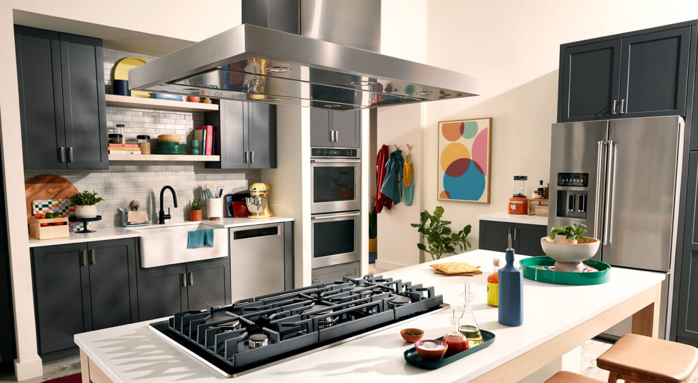 KitchenAid® wall oven, cooktop, range hood, dishwasher and refrigerator appliance suite in a modern kitchen KitchenAid® wall oven, cooktop, range hood, dishwasher and refrigerator appliance suite in a modern kitchen