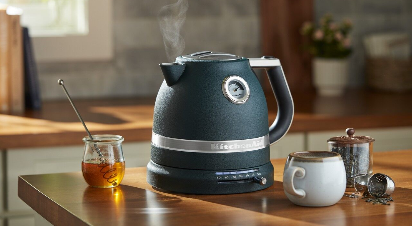 Black KitchenAid® electric kettle next to tea accessories and honey Black KitchenAid® electric kettle next to tea accessories and honey