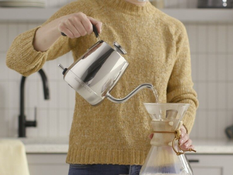 Woman making pour over coffee with a gooseneck kettle