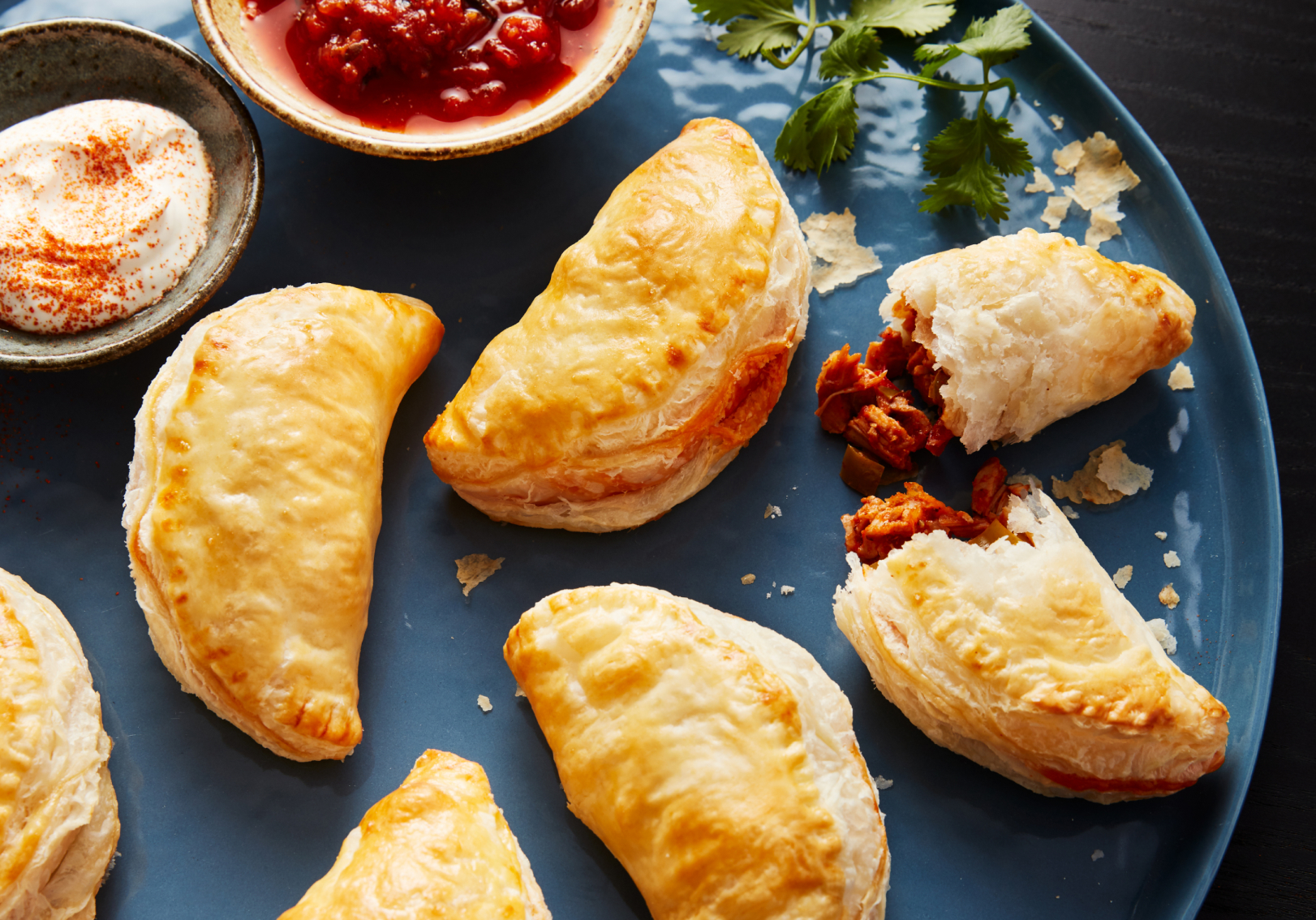 Empanadas on blue serving tray with dip Empanadas on blue serving tray with dip